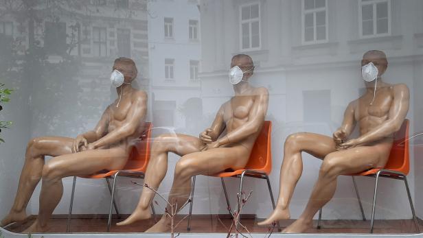Schaufensterpuppen mit Schutzmasken in einer Wiener Auslage.