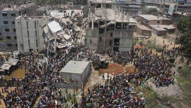 Crowds gather at the collapsed Rana Plaza building as people rescue garment workers trapped in the rubble, in Savar, 30 km (19 miles) outside Dhaka April 24, 2013. The eight-storey block housing garment factories and a shopping centre collapsed on the outskirts of the Bangladeshi capital on Wednesday, killing at least 25 people and injuring more than 500, the Ntv television news channel reported. REUTERS/Andrew Biraj (BANGLADESH - Tags: DISASTER BUSINESS EMPLOYMENT)