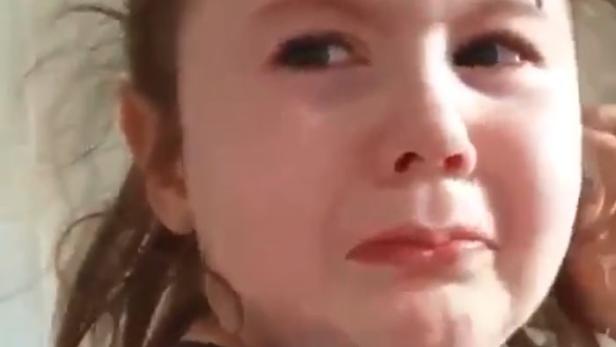 Ein weinendes kleines Mädchen mit Tränen im Gesicht.