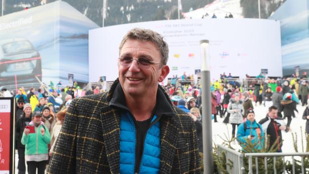 Ein lächelnder Mann steht vor einer Zuschauermenge beim FIS Ski World Cup in Kitzbühel.