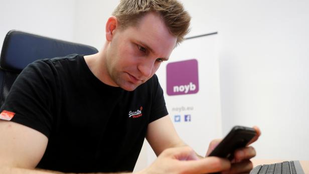 FILE PHOTO: Austrian lawyer and privacy activist Schrems checks his mobile phone in his office in Vienna