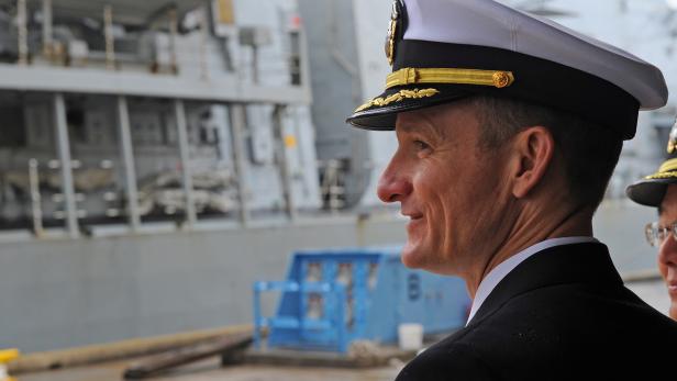 Captain Brett E. Crozier watches Royal Navy HMS Sutherland as she arrives in Yokosuka