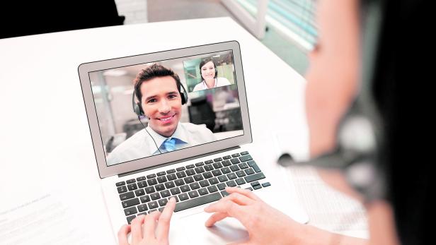 Businesswoman in the office on videoconference with headset, Skype