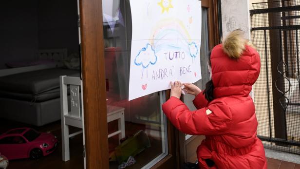 Kind vor einer Schule in der Stadt Manta mit seiner Zeichnung &quot;Alles wird gut&quot;.