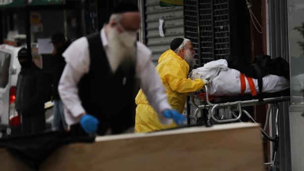 Ein orthodoxer Jude mit einem Holzsarg in Brooklyn, New York.
