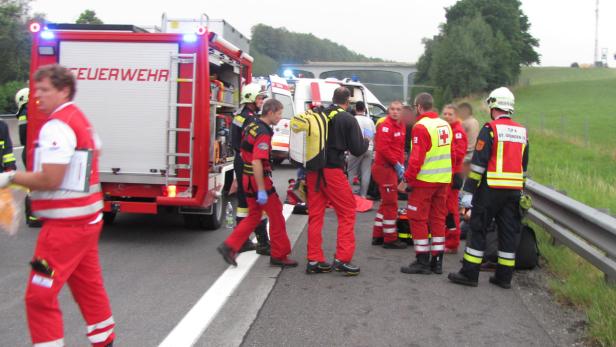 Einsatzkräfte von Feuerwehr und Rettungsdienst sind an einem Unfallort auf der Autobahn im Einsatz.