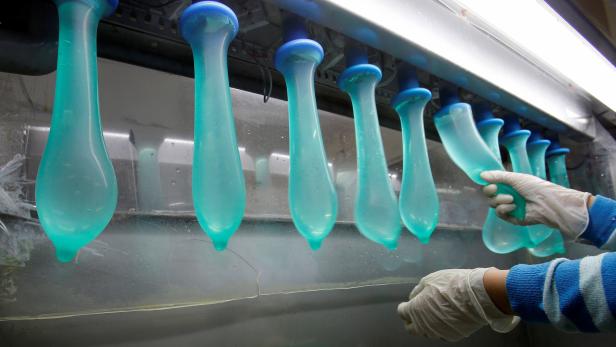FILE PHOTO: A worker performs a test on condoms at Malaysia's Karex condom factory in Pontian