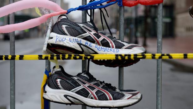 epa03673987 Running sneakers hang as a memorial for victims of the bombings at the finish line of the Boston Marathon in Boston, Massachusetts, USA, 23 April 2013. Three people were killed and over 170 people were injured when two bombs exploded on 15 April 2013 at the finish line of the marathon. EPA/JUSTIN LANE