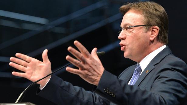 Ein Mann mit Brille gestikuliert an einem Rednerpult.