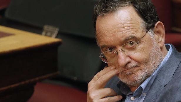 Ein Mann mit Brille und Bart berührt nachdenklich sein Kinn.