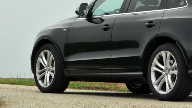 Ein schwarzer Audi Q5 steht auf einer unbefestigten Straße.