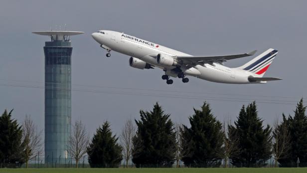 An Airbus A330 Air France airplane takes off past a control tower at the Charles-de-Gaulle airport in Roissy during an air traffic controller strike