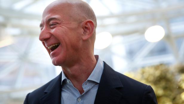 FILE PHOTO: Amazon founder and CEO Jeff Bezos laughs as he talks to the media while touring the new Amazon Spheres during the grand opening in Seattle