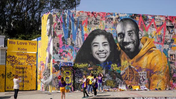 Fans gather around a mural of late NBA great Kobe Bryant and his daughter Gianna Bryant during a public memorial for them and seven others killed in a helicopter crash, at the Staples Center in Los Angeles