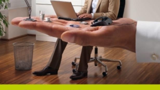 Ein Mann sitzt auf einer Handfläche, die als Schreibtisch mit Laptop, Lampe und Telefon dient.