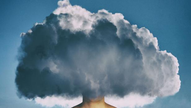 Eine Wolke verdeckt den Kopf einer Person vor einem blauen Himmel.