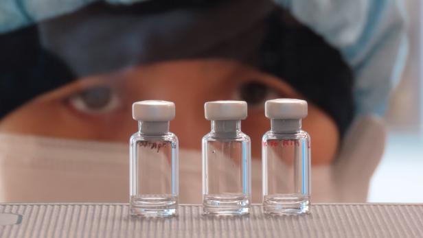 A scientist checks quality control of vaccine vials for correct volume at the Clinical Biomanufacturing Facility (CBF) in Oxford