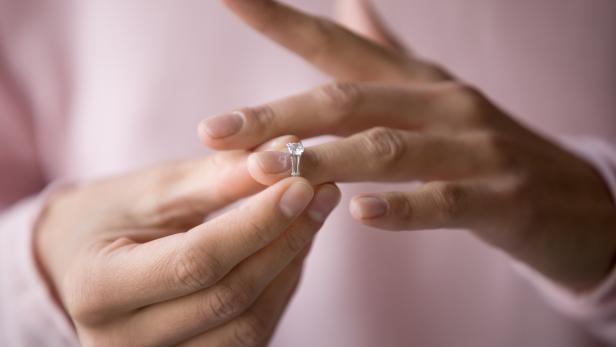 Close up of woman removing ring filing for divorce
