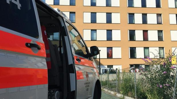 Ein Rettungswagen des Österreichischen Roten Kreuzes steht vor einem Gebäude.