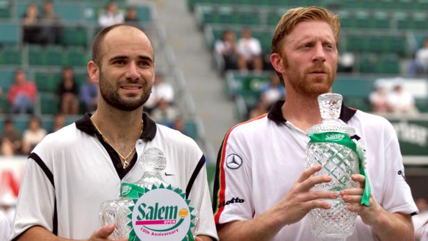 FILE PHOTO: Andre Agassi and Boris Becker pose with their respective trophies after the final of the Salem Open in Hong Kong -- the 14th and last meeting between the two.