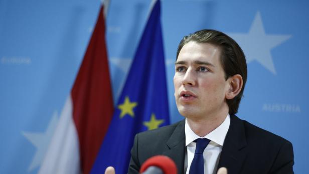 Sebastian Kurz bei einer Rede vor österreichischer und EU-Flagge.