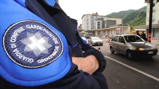 A Swiss customs officer stands by during a demonstration against cost reduction plans and possible job cuts, on the Swiss-Italian border, in Chiasso May 29, 2010. REUTERS/Fiorenzo Maffi (SWITZERLAND - Tags: EMPLOYMENT BUSINESS POLITICS)