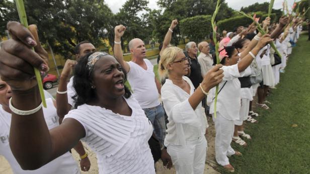 Berta Soler (L) of the &quot;Ladies in White&quot; shouts slogans during a protest march in homage of Laura Pollan along the main avenue of the upscale Havana district of Miramar in Havana October 16, 2011. The dissident group Ladies in White sent a message of defiance to the Cuban government on Sunday, having men join them for their weekly protest march and vowing to go on despite the death of leader Laura Pollan. Pollan led the founding of the Ladies in White to demand freedom for her husband and 74 other dissidents after they were imprisoned in a March 2003 government crackdown. REUTERS/Enrique De La Osa (CUBA - Tags: OBITUARY CIVIL UNREST POLITICS)