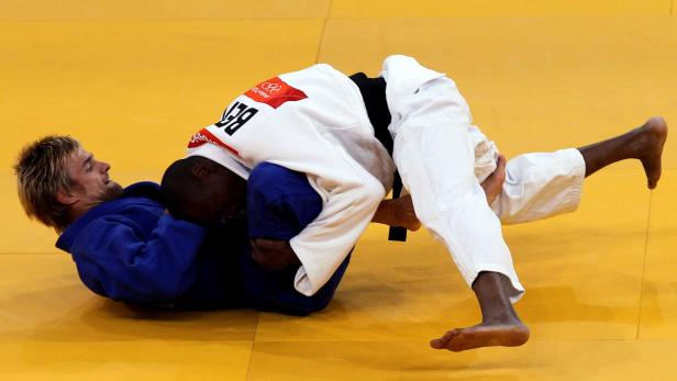 epa03321431 Jacob Gnahoui of Benin (white) competes against Ludwig Paischer of Austria (blue) during their men&#039;s 60kg elimination round match for the London 2012 Olympic Games Judo Competition, London, Britain, 28 July 2012. EPA/ORESTIS PANAGIOTOU ORJ01