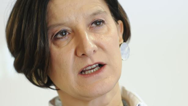 Nahaufnahme einer Frau mit dunklen Haaren und Ohrringen.