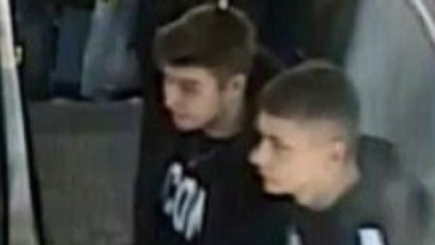 Zwei junge Männer gehen nebeneinander her.