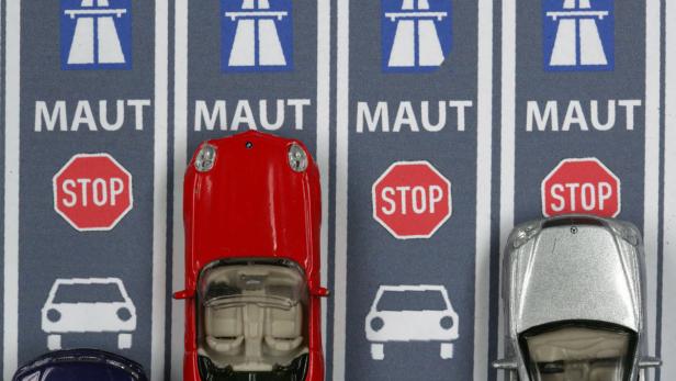 Spielzeugautos stehen an einer Mautstelle mit Stoppschildern.