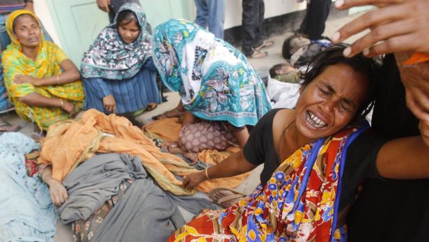 People mourn in front of the remains of their relatives, who died inside the rubble of the collapsed Rana Plaza building, in Savar, 30 km (19 miles) outside Dhaka April 25, 2013. The number of people killed by the collapse of a building in Bangladesh&#039;s capital rose to 147 overnight and the death toll could climb further because many people are still trapped inside, Dhaka&#039;s district police chief told Reuters on Thursday. REUTERS/Andrew Biraj (BANGLADESH - Tags: DISASTER TPX IMAGES OF THE DAY)