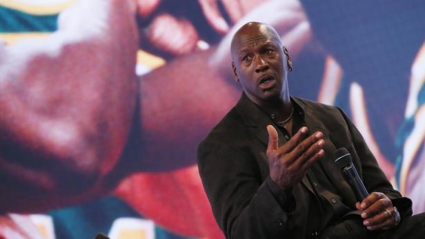 Michael Jordan spricht bei einer Veranstaltung in ein Mikrofon.