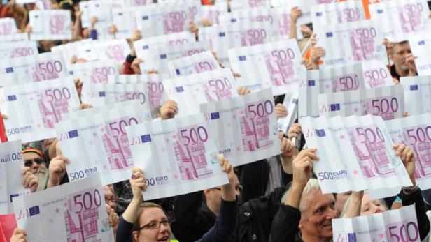 epa03414857 Protesters hold large mock 500 euro notes during a demonstration in Frankfurt, Germany, 29 September 2012. The organisation Attac, work unions and social organisations had called for a protest day. Central demands are among others a permanent tax on wealth and a one-time concession tax as well as effective methods against tax evasion. T EPA/ARNE DEDERT