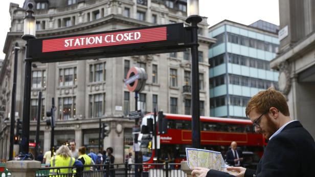 Ein Mann studiert eine Karte vor einer geschlossenen Londoner U-Bahn-Station.
