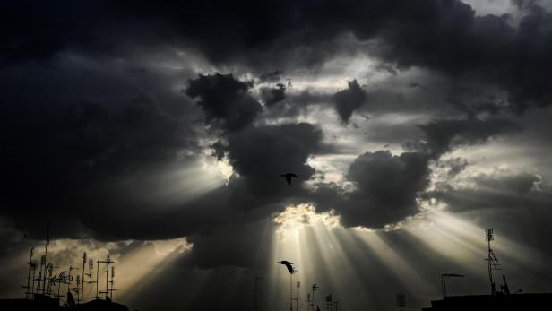 Möwen fliegen gegen die Skyline von Rom, während die Sonne durch die Wolken des frühen Morgens bricht.