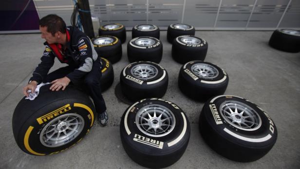 A Red Bull Formula One team member inspects Pirelli tyres near the pits at the Chinese F1 Grand Prix at the Shanghai International Circuit April 11, 2013. REUTERS/Carlos Barria (CHINA - Tags: SPORT MOTORSPORT)