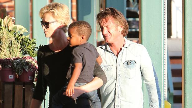 Charlize Theron und Sean Penn mit einem Kind im Arm.