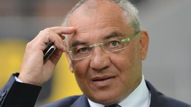 Ein Mann mit Brille hält ein Mobiltelefon an sein Ohr.