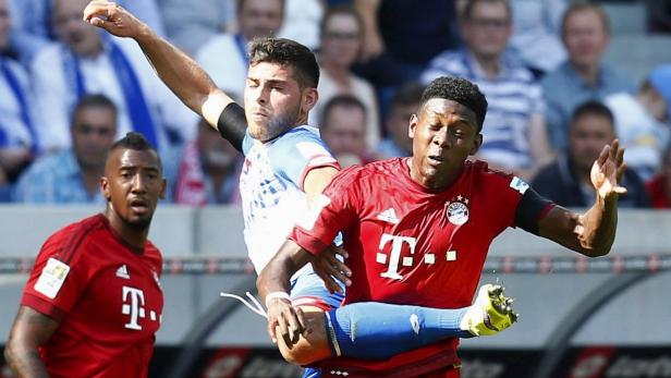 Zwei Fußballspieler kämpfen um den Ball während eines Spiels.