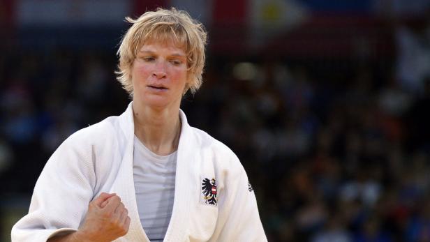 Eine Judoka im weißen Judoanzug mit dem österreichischen Wappen.