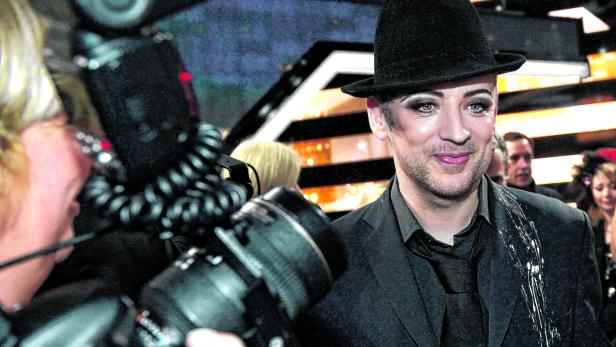Boy George posiert für ein Foto mit Hut und auffälligem Make-up.
