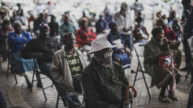 Ein älterer Mann an einem SASSA-Zahlpunkt (South African Social Security Agency) in Soweto hält sich in der Warteschlange den Mund zu. Südafrika wurde am 27. März 2020 landesweit gesperrt und verhängte zusammen mit anderen afrikanischen Ländern strenge Au