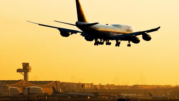 Tablet eingeklemmt: Deshalb musste ein Lufthansaflug notlanden. Ein Lufthansaflugzeug setzt im Sonnenuntergang zur Landung an