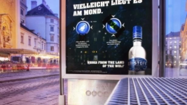 Eine Bushaltestelle mit einer Werbung für „Kristoff“-Wodka, auf der ein Wolf vor einem Vollmond zu sehen ist.