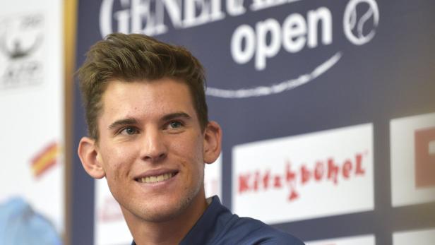Dominic Thiem lächelt vor einem Banner des Generali Open in Kitzbühel.