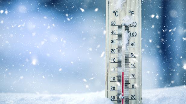 EIn Thermometer, das Minusgrade anzeigt, steckt im Schnee.