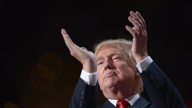 Donald Trump gestikuliert mit erhobenen Händen.