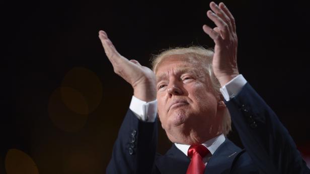 Donald Trump gestikuliert mit erhobenen Händen.