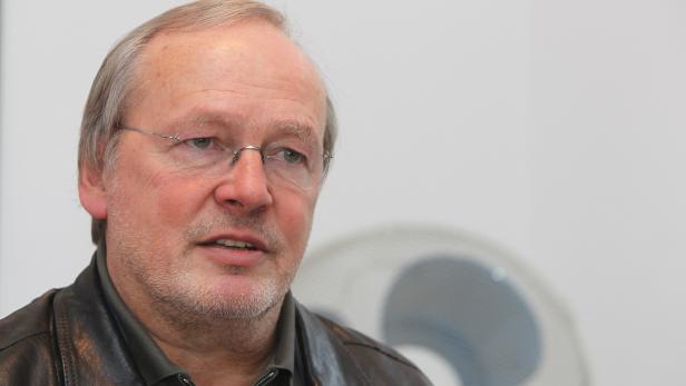 Ein Mann mit Brille und Lederjacke schaut zur Seite.
